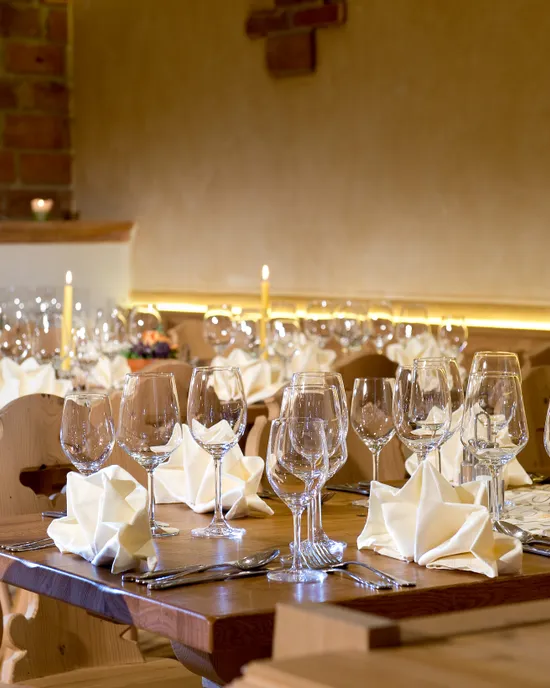 Elegante Restauranttischdekoration mit Weingläsern, gefalteten Servietten und Kerzenlicht